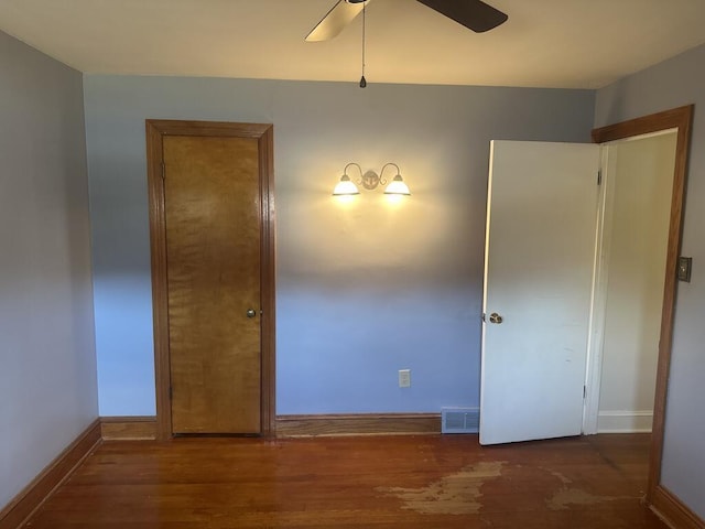 unfurnished bedroom featuring visible vents, ceiling fan, baseboards, and wood finished floors