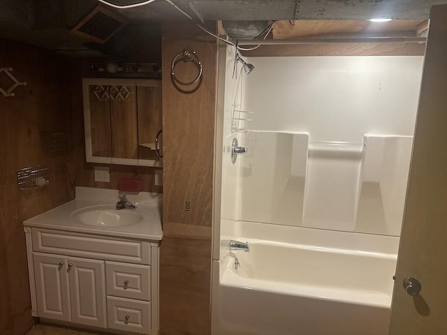 full bath featuring vanity, washtub / shower combination, and visible vents