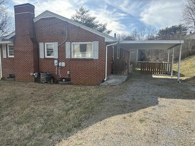 rear view of property with a lawn, brick siding, and a chimney