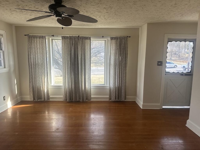 interior space featuring baseboards, a textured ceiling, ceiling fan, and wood finished floors