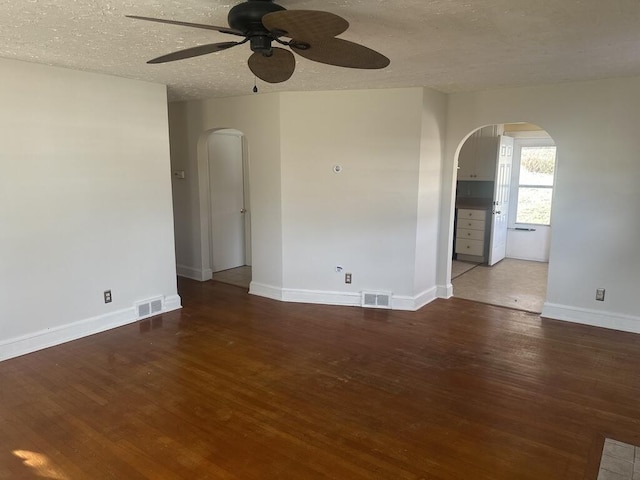 spare room with arched walkways, visible vents, and ceiling fan