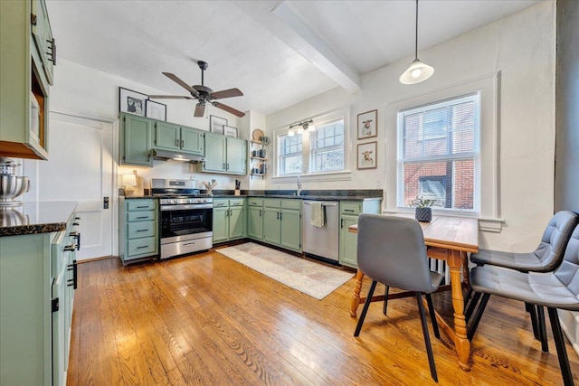 kitchen featuring light wood finished floors, green cabinets, ceiling fan, under cabinet range hood, and stainless steel appliances