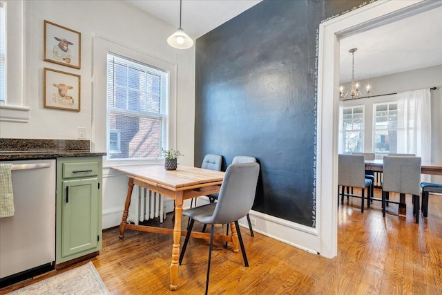 dining room with an inviting chandelier, baseboards, and light wood-type flooring