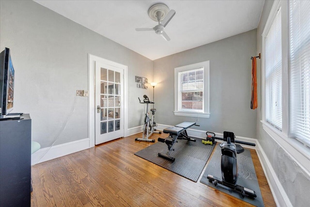 workout room with ceiling fan, baseboards, and wood finished floors