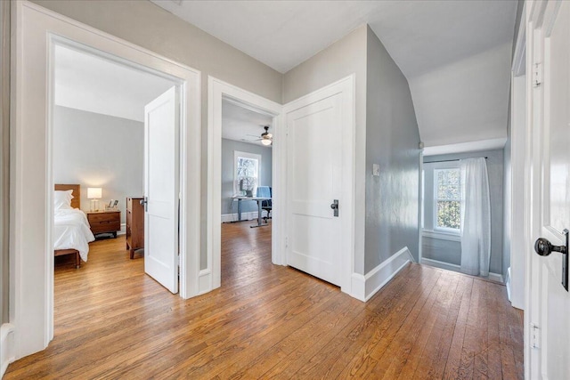 corridor featuring baseboards and light wood-style flooring