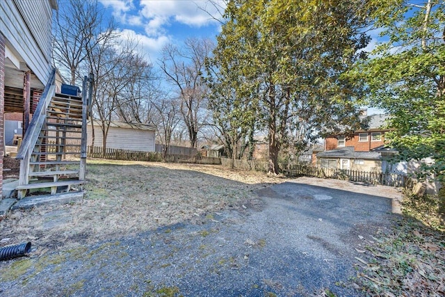 view of yard featuring stairs and fence