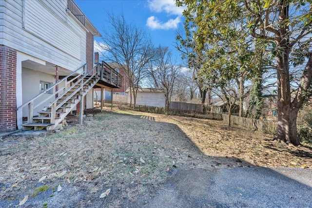 view of yard featuring stairway, a wooden deck, and fence