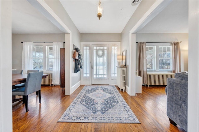 foyer featuring a wealth of natural light, hardwood / wood-style floors, and radiator heating unit