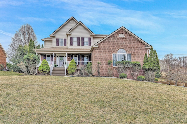 traditional home with brick siding, a porch, and a front yard