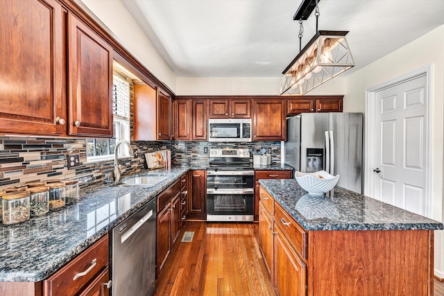 kitchen with backsplash, dark wood-style flooring, appliances with stainless steel finishes, and a sink