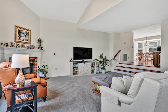 living room with visible vents, baseboards, carpet, stairs, and a fireplace