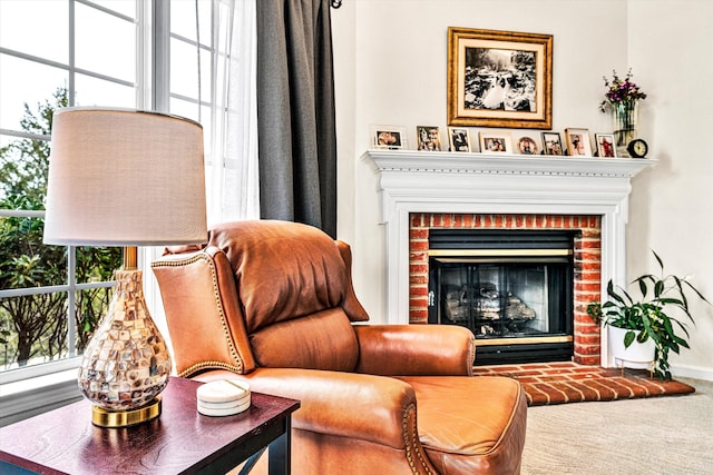 sitting room featuring a brick fireplace and carpet