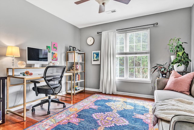 office area with visible vents, baseboards, ceiling fan, and wood finished floors