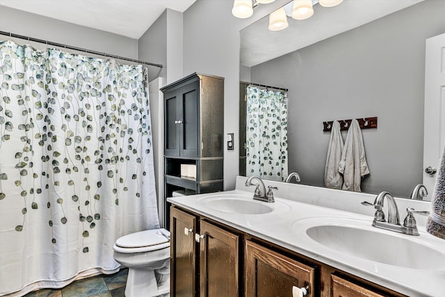 bathroom featuring a shower with shower curtain, double vanity, toilet, and a sink