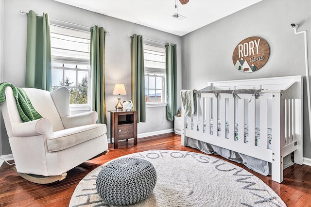 bedroom featuring multiple windows, baseboards, and wood-type flooring