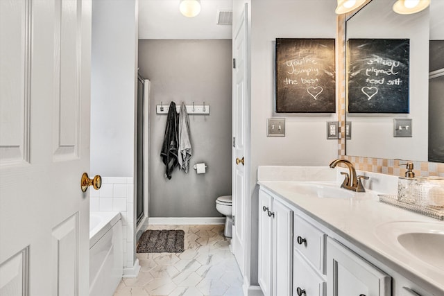 bathroom featuring visible vents, toilet, a garden tub, a sink, and double vanity