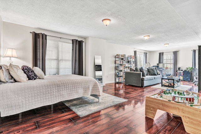 bedroom featuring wood finished floors, baseboards, and a textured ceiling