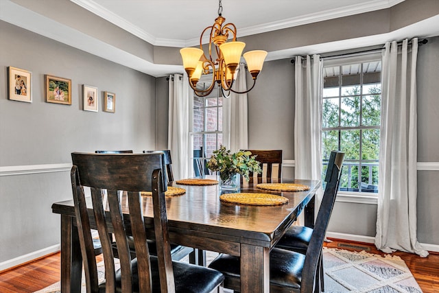 dining area featuring baseboards, an inviting chandelier, wood finished floors, and crown molding