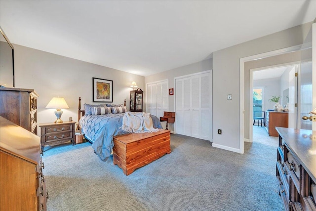 bedroom featuring baseboards, two closets, and carpet