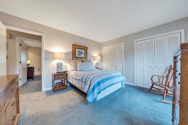 bedroom featuring light colored carpet, baseboards, and two closets