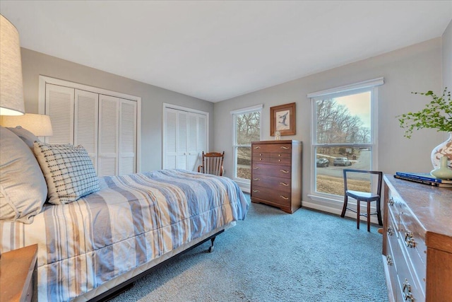 bedroom featuring carpet and multiple closets