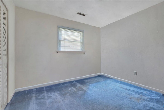 unfurnished room with visible vents, baseboards, and carpet flooring