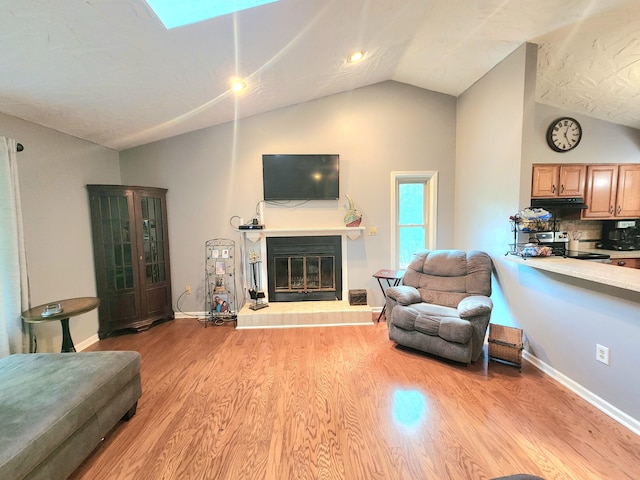 7167 Bent Mountain Rd, Roanoke, VA 24018 - living room featuring a glass covered fireplace, baseboards, vaulted ceiling, and light wood-style floors