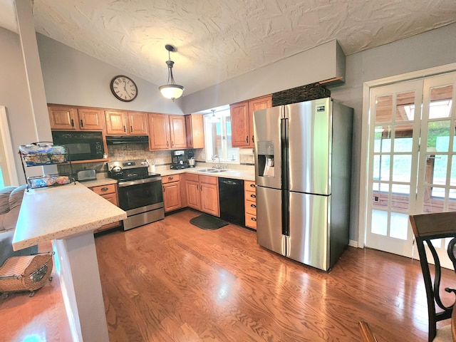 7167 Bent Mountain Rd, Roanoke, VA 24018 - kitchen featuring tasteful backsplash, light wood-style flooring, a sink, under cabinet range hood, and black appliances