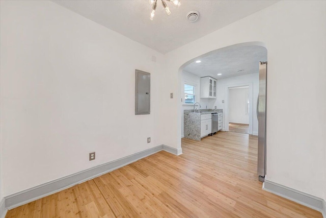 821 Kerns Ave SW, Roanoke, VA 24015 - unfurnished room featuring arched walkways, electric panel, and light wood-style floors