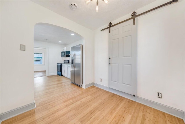 821 Kerns Ave SW, Roanoke, VA 24015 - interior space with arched walkways, light wood finished floors, a barn door, and recessed lighting