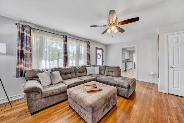 living room with baseboards, a baseboard radiator, ceiling fan, and hardwood / wood-style flooring