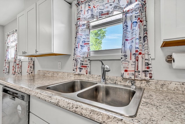 kitchen with white cabinetry, stainless steel dishwasher, and a sink