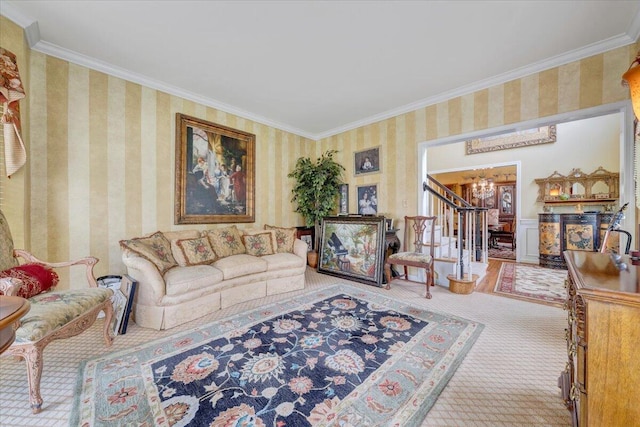 carpeted living area with a notable chandelier, crown molding, wallpapered walls, and stairway
