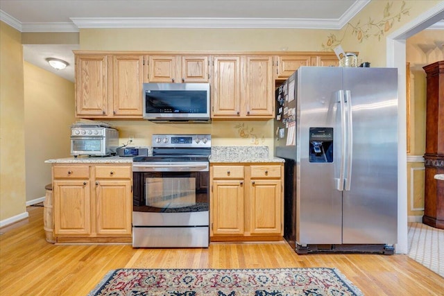 kitchen featuring appliances with stainless steel finishes, light wood-style flooring, baseboards, and ornamental molding