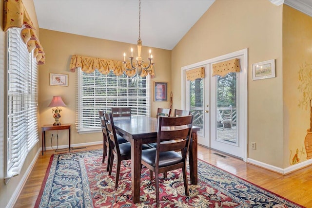 dining room with baseboards, a chandelier, wood finished floors, and visible vents