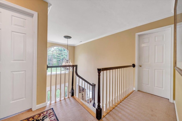 hallway with an upstairs landing, baseboards, ornamental molding, and carpet floors