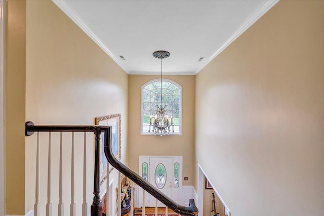 interior space featuring an inviting chandelier, crown molding, and visible vents