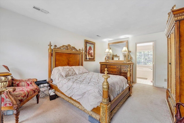 bedroom featuring connected bathroom, visible vents, and light carpet