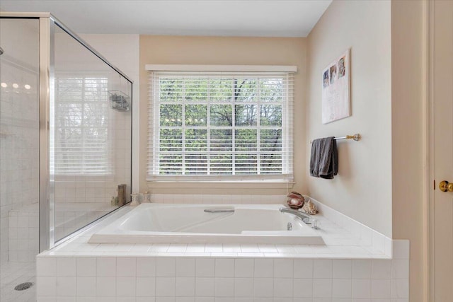 bathroom featuring a bath, a wealth of natural light, and a stall shower