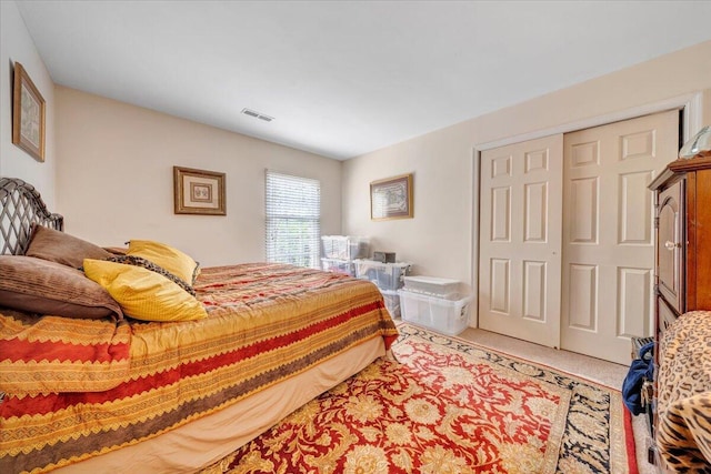 carpeted bedroom with a closet and visible vents