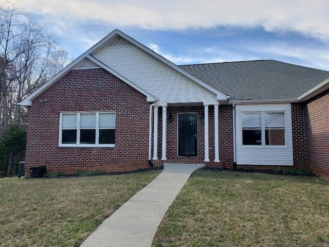 ranch-style house with central AC, a front lawn, brick siding, and a shingled roof