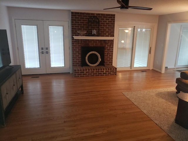living area with baseboards, a ceiling fan, french doors, and wood finished floors