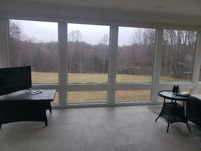 sunroom / solarium with a view of trees and a healthy amount of sunlight