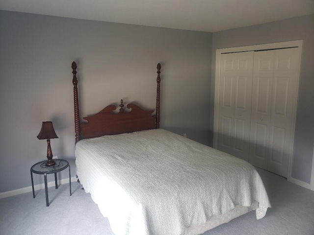 carpeted bedroom with a closet and baseboards