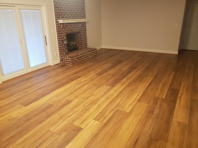 unfurnished living room featuring baseboards and wood finished floors