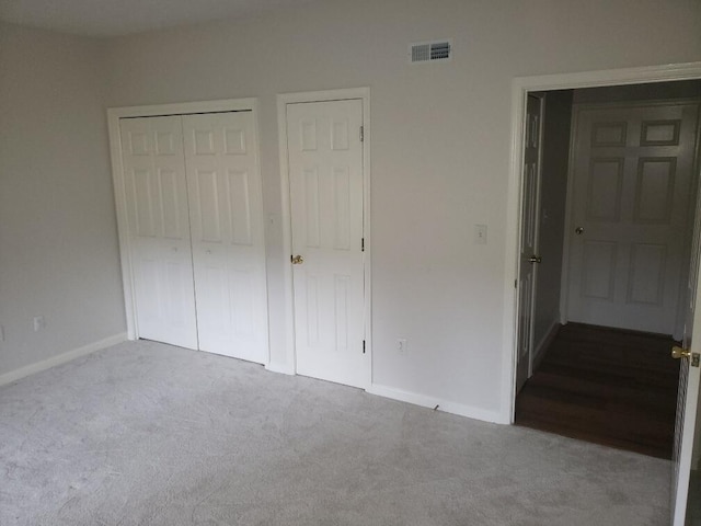 unfurnished bedroom featuring baseboards, visible vents, a closet, and carpet flooring