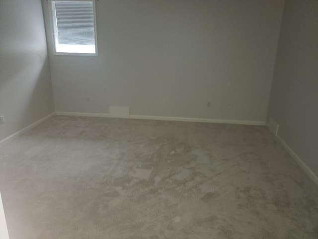unfurnished room featuring baseboards and carpet flooring
