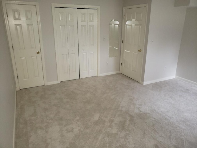 unfurnished bedroom featuring baseboards, a closet, and carpet