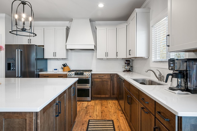 1042 Round Meadow Dr, Christiansburg, VA 24073 - kitchen with high quality fridge, custom range hood, double oven range, a sink, and light wood-style floors