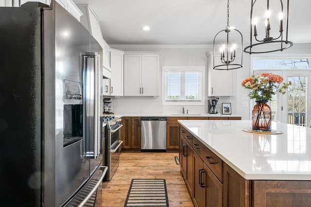 1042 Round Meadow Dr, Christiansburg, VA 24073 - kitchen with stainless steel appliances, a sink, healthy amount of natural light, light countertops, and ornamental molding